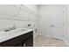 Practical laundry room featuring a sink, dark cabinets, quartz countertop, and wire rack for efficient organization at 1300 Dali Blvd, Mount Holly, NC 28120