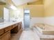 Bright primary bathroom featuring dual sinks, a soaking tub, and linen closet at 13037 Angel Oak Dr, Huntersville, NC 28078
