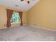 Spacious bedroom with a vaulted ceiling, neutral carpet, and large window at 13037 Angel Oak Dr, Huntersville, NC 28078