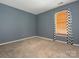 Blue bedroom with carpet and window with black and white curtains at 13037 Angel Oak Dr, Huntersville, NC 28078