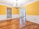 Bright dining room featuring hardwood floors, wainscoting, and a modern chandelier at 13037 Angel Oak Dr, Huntersville, NC 28078