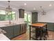 Bright kitchen featuring stainless steel appliances, green cabinets, marble counters and access to a deck or patio at 13037 Angel Oak Dr, Huntersville, NC 28078