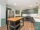 Modern kitchen with green cabinets, stainless steel appliances, and a kitchen island, perfect for cooking and entertaining at 13037 Angel Oak Dr, Huntersville, NC 28078