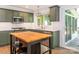 Stylish kitchen with green cabinetry, stainless steel appliances, marble countertops and an island with stool seating at 13037 Angel Oak Dr, Huntersville, NC 28078