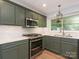 Updated kitchen featuring stainless steel appliances, green cabinets, and marble countertops offering a sleek design at 13037 Angel Oak Dr, Huntersville, NC 28078