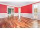Spacious living room with hardwood floors, wainscoting, and bright red accent wall at 13037 Angel Oak Dr, Huntersville, NC 28078