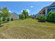 A well-maintained, grassy backyard featuring a black fence and view of the home's exterior at 1324 Mona Vale Dr, Huntersville, NC 28078
