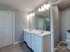 Modern bathroom with double sink vanity, white cabinets, and white tiled floors at 1324 Mona Vale Dr, Huntersville, NC 28078