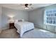 Comfortable bedroom with window, ceiling fan, a double bed, and an end table with lamp at 1324 Mona Vale Dr, Huntersville, NC 28078