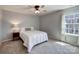 Comfortable bedroom with window, ceiling fan, a double bed, and an end table with lamp at 1324 Mona Vale Dr, Huntersville, NC 28078