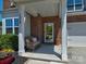 Inviting front porch with stylish wicker seating, potted plants, and a decorative wreath adorning the front door at 1324 Mona Vale Dr, Huntersville, NC 28078