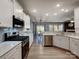 Modern kitchen with white cabinetry, stainless steel appliances, and a view into the dining area at 1324 Mona Vale Dr, Huntersville, NC 28078