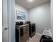 Modern laundry room featuring a stainless steel washer and dryer with a tile floor at 1324 Mona Vale Dr, Huntersville, NC 28078