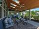 Covered patio with ceiling fans, skylights, stone floors, and comfortable seating at 1324 Mona Vale Dr, Huntersville, NC 28078