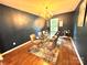 Dining area features a glass top table, tan upholstered chairs, contemporary chandelier, hardwood floors, and dark walls at 1528 Magnolia Dr # 8, Lancaster, SC 29720