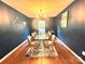 Dining area features a glass top table, tan upholstered chairs, contemporary chandelier, hardwood floors, and dark walls at 1528 Magnolia Dr # 8, Lancaster, SC 29720