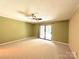 Bedroom features neutral carpet, a ceiling fan, and a sliding glass door leading to a private outdoor space at 1590 Springpoint Rd # B, Rock Hill, SC 29732