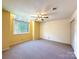 Cozy bedroom featuring carpeted floors, a ceiling fan, and a large window offering natural light at 1590 Springpoint Rd # B, Rock Hill, SC 29732