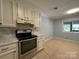 Kitchen featuring modern appliances, white cabinetry, tile floors, and a bright window at 1590 Springpoint Rd # B, Rock Hill, SC 29732