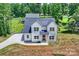 Aerial view of a modern two-story home with a long driveway and lush greenery, showcasing elegance and tranquility at 164 Meadow Glen Dr, Troutman, NC 28166