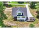 Aerial view of the house showcasing the backyard, driveway, and surrounding trees at 164 Meadow Glen Dr, Troutman, NC 28166