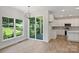 Bright dining area with large windows and sliding door adjacent to an open-concept kitchen at 164 Meadow Glen Dr, Troutman, NC 28166