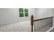 Upstairs hallway featuring an ornate metal railing with a view to green, lush trees outside the window at 164 Meadow Glen Dr, Troutman, NC 28166