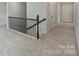 Carpeted hallway featuring an ornate metal railing and white trim at 164 Meadow Glen Dr, Troutman, NC 28166