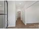 A bright and airy hallway with beautiful wood floors leading to various rooms, offering a seamless transition throughout at 164 Meadow Glen Dr, Troutman, NC 28166