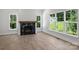 An open living room features a fireplace and large windows providing views of the backyard at 164 Meadow Glen Dr, Troutman, NC 28166