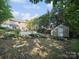 A beautiful fenced in backyard with mature trees and a storage shed near the in-ground pool at 16411 Greybriar Forest Ln, Charlotte, NC 28278
