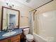 Cozy bathroom with blue vanity, toilet and tub with shower at 16411 Greybriar Forest Ln, Charlotte, NC 28278