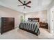 Spacious bedroom with a ceiling fan, neutral carpet, and a large bed with two nightstands and dark wood furniture at 16411 Greybriar Forest Ln, Charlotte, NC 28278