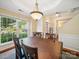 Bright dining room featuring a large window, hardwood floors, and an elegant chandelier above the wooden table at 16411 Greybriar Forest Ln, Charlotte, NC 28278