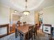 Open-concept dining room with hardwood floors, a large wooden table, and easy access to the staircase and kitchen at 16411 Greybriar Forest Ln, Charlotte, NC 28278