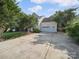 Long driveway leading to a two-car garage with well-manicured landscaping around the house at 16411 Greybriar Forest Ln, Charlotte, NC 28278