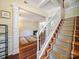 Grand foyer showcasing a staircase with patterned carpet, elegant columns, and an entrance into a cozy living room at 16411 Greybriar Forest Ln, Charlotte, NC 28278