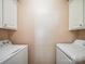 Efficient laundry room setup with washer and dryer, plus upper cabinets for storage at 16411 Greybriar Forest Ln, Charlotte, NC 28278