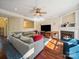 Comfortable living room with hardwood floors, fireplace, large screen tv, and a cozy sectional couch at 16411 Greybriar Forest Ln, Charlotte, NC 28278