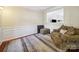 Comfortable living room featuring a cozy chair, plush rug, and elegant wainscotting and hardwood floors at 16411 Greybriar Forest Ln, Charlotte, NC 28278