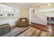 Comfortable living room featuring a cozy chair, plush rug, and a view into the dining room and staircase at 16411 Greybriar Forest Ln, Charlotte, NC 28278