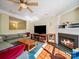 Cozy living room featuring a fireplace, large sectional couch, hardwood floors, and bright natural light at 16411 Greybriar Forest Ln, Charlotte, NC 28278