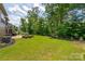 Expansive backyard with lush green grass, mature trees, and outdoor seating area at 1805 Trading Path Ln, Waxhaw, NC 28173