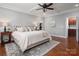 This primary bedroom features a tray ceiling, hardwood floors, and a tufted headboard at 1805 Trading Path Ln, Waxhaw, NC 28173