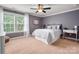 Cozy bedroom featuring a ceiling fan, natural light from large windows, and neutral decor at 1805 Trading Path Ln, Waxhaw, NC 28173