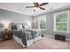 Comfortable bedroom with ceiling fan, two windows, and stylish decor at 1805 Trading Path Ln, Waxhaw, NC 28173