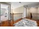 This upstairs hallway features hardwood floors, natural light, and decorative railing at 1805 Trading Path Ln, Waxhaw, NC 28173