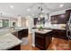 Gourmet kitchen with granite countertops, stainless steel appliances, and dark wood cabinetry at 1805 Trading Path Ln, Waxhaw, NC 28173