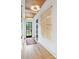 Bright hallway showcasing hardwood floors, stylish light fixtures, and a unique wall hanging at 1830 Commodore St, Charlotte, NC 28205
