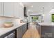 A bright kitchen features stainless steel appliances, a wine cooler, and a large kitchen island with stone countertops at 1830 Commodore St, Charlotte, NC 28205